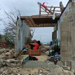 Person in a chair in a destroyed home.