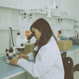 Woman in a labcoat at a microscope
