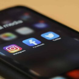 Instagram, Facebook, Twitter icons on a phone