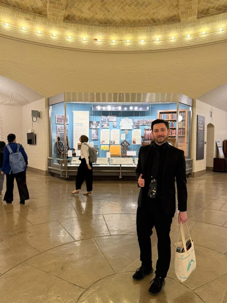 Evan Raskin standing in the rotunda giving a thumbs up