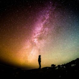 Person looking up at a colorful night sky