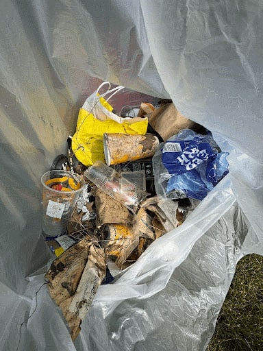 Trash in a trash bag that has been collected as a cleanup