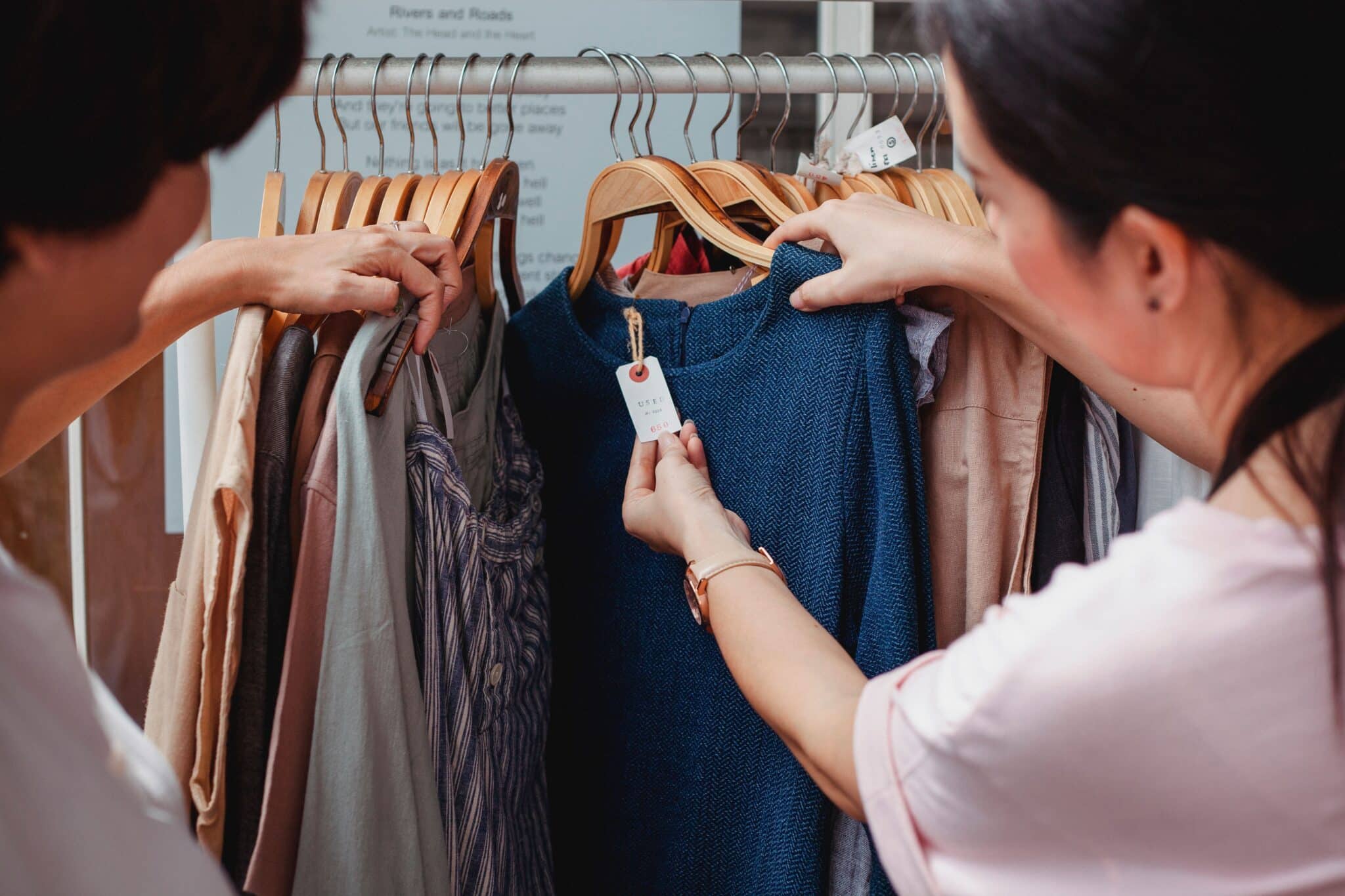 Two people examine a clothing tag