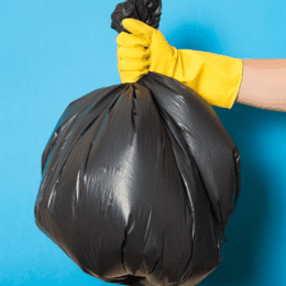 Gloved hand holding trashbag