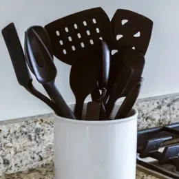 Black plastic utensils in a holder