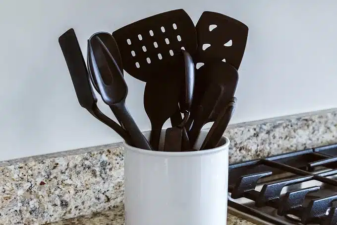Black plastic utensils in a holder
